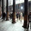 Tourists between the huge red sandstone pillars in the Church of the Nativity