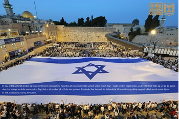 Et hav af blå og hvidt breder sig foran Vestmuren i Jerusalem. Tusindvis af mennesker står samlet under Israels flag – nogle synger, nogle beder, andre står blot stille og ser på de gamle sten. For mange er dette mere end et flag. Det er et symbol på et folk, der gennem årtusinder har bevaret sin forbindelse til Jerusalem og aldrig opgivet håbet om at vende hjem. Et folk. En historie. En by. Jerusalem. 
