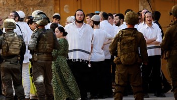Israelske bosættere følges af soldater under en ugentlig vandring i byen Hebon på Vestbred.